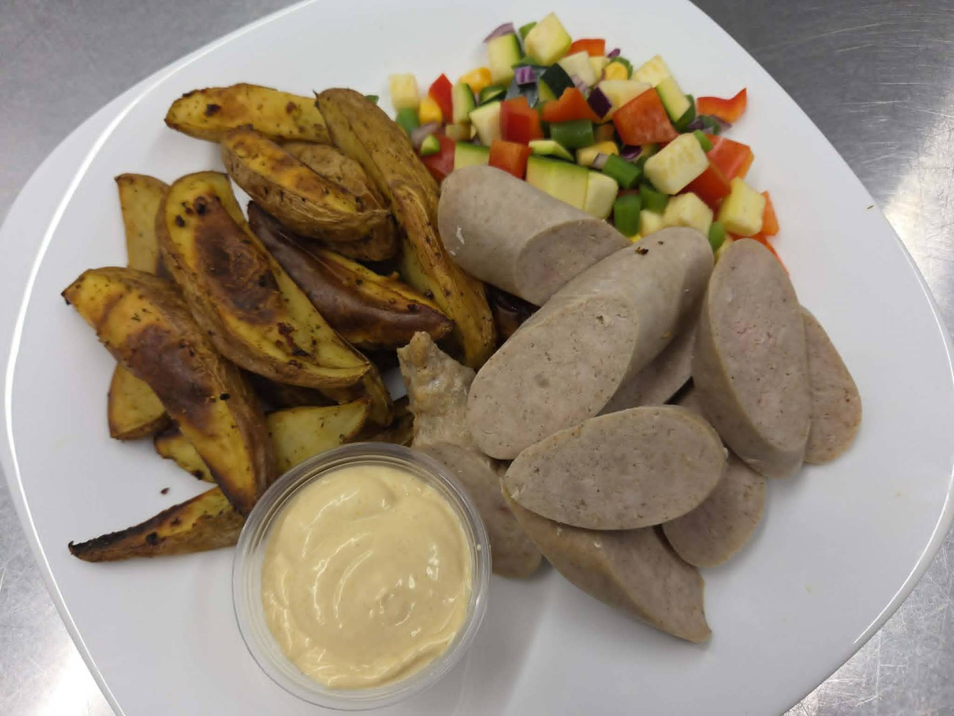 Saucisses de poulet Toulouse, pommes de terre grecques et mélange de légumes d'été