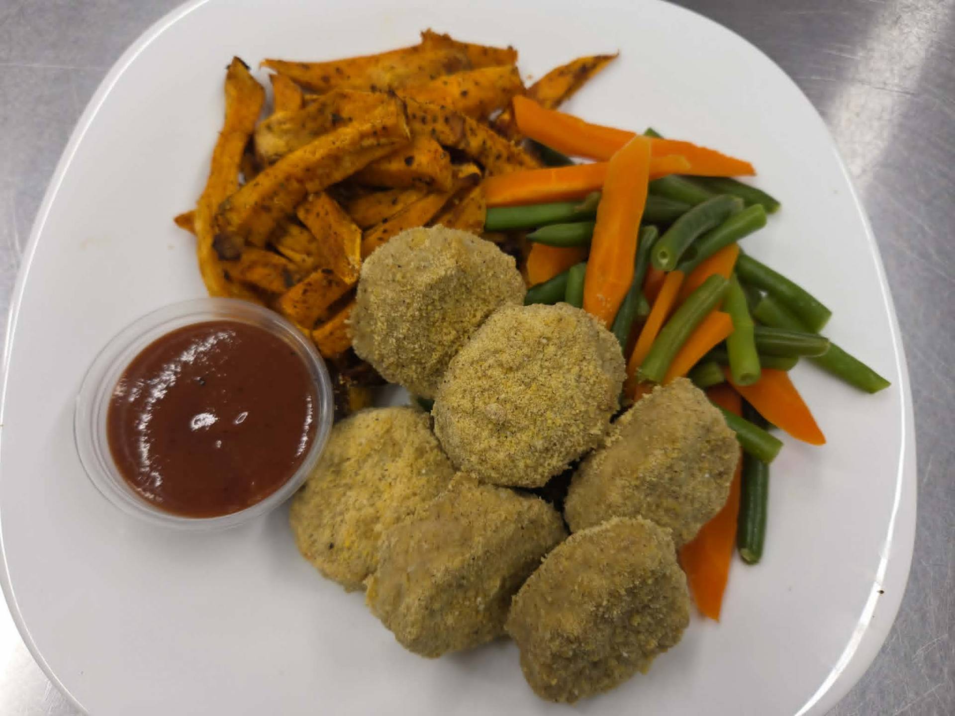 Croquettes de poulet, frites de patates douces cajun, haricots verts et carottes