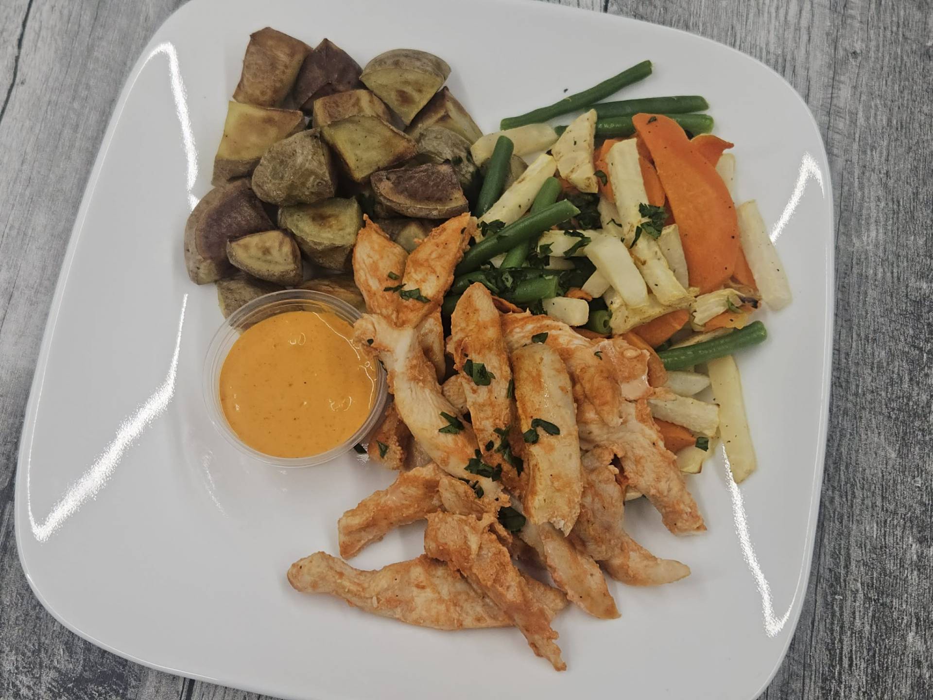 Lanières de poulet marinées aux poivrons rôtis, pommes de terre, trio de légumes, haricots verts