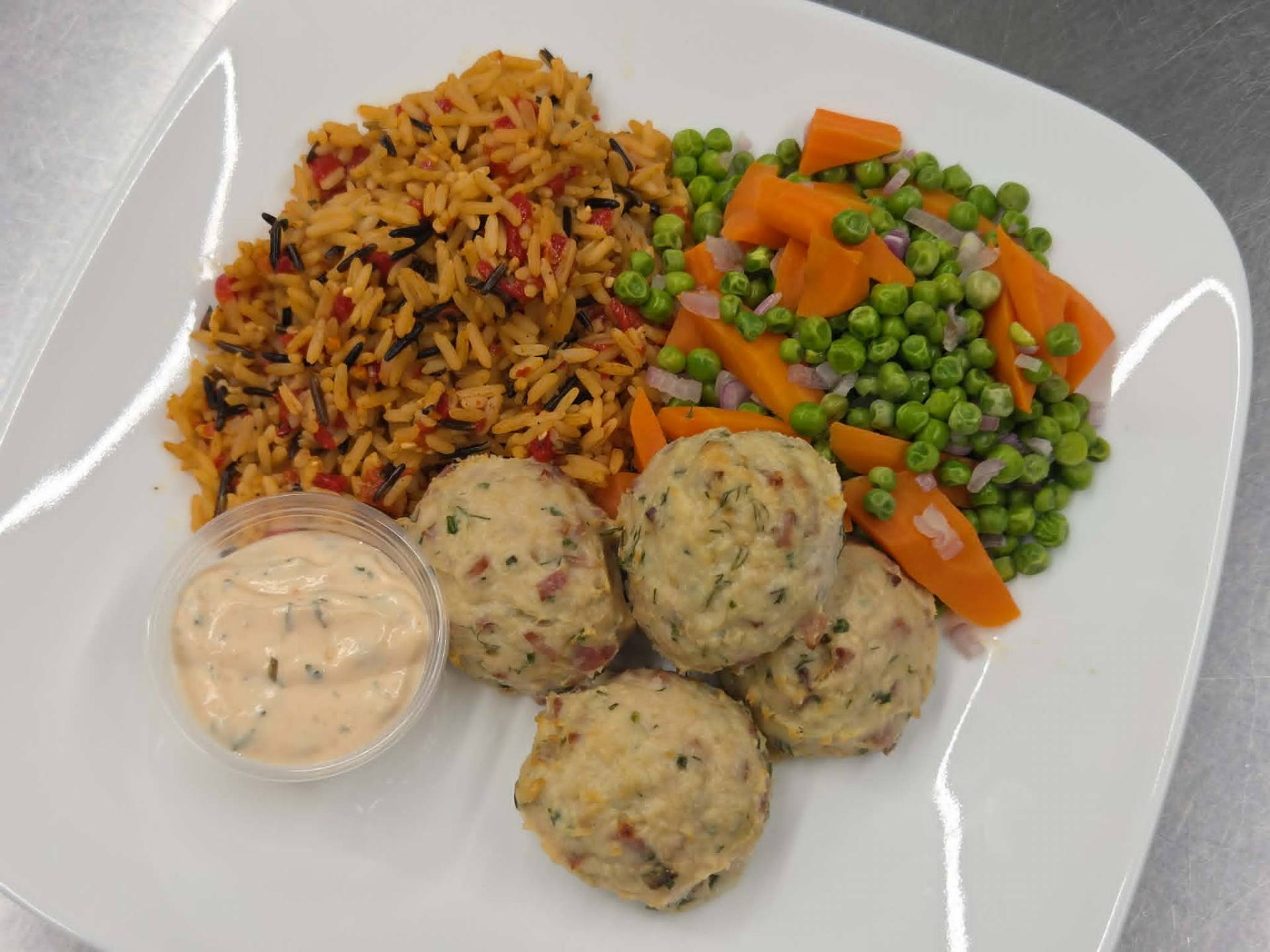 Boulettes de poulet au bacon de dinde, riz sauvage aux poivrons rotis, pois verts et carottes