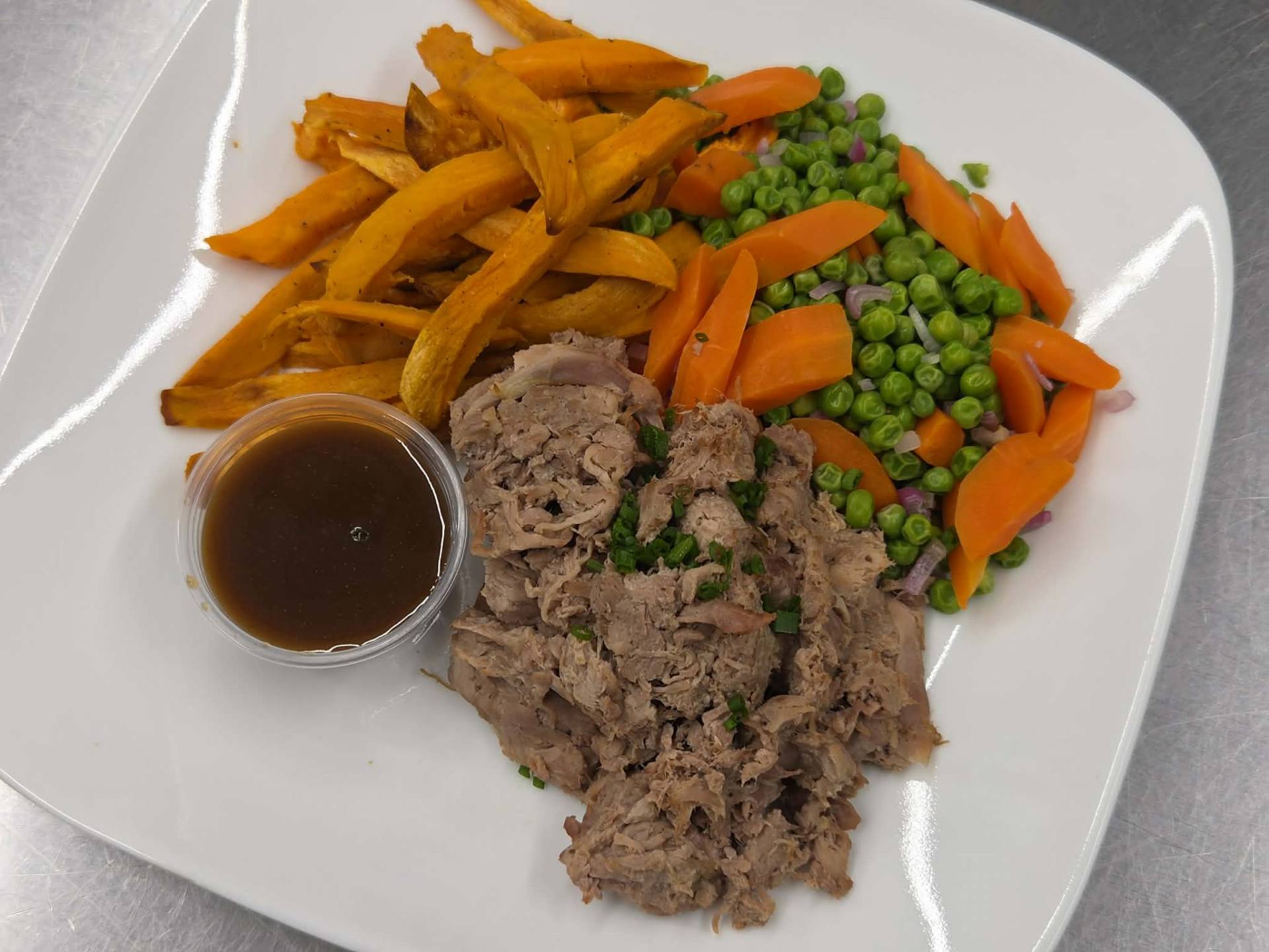 Canard effiloché, frites de patates douces, petits pois verts et carottes à l'échalotte