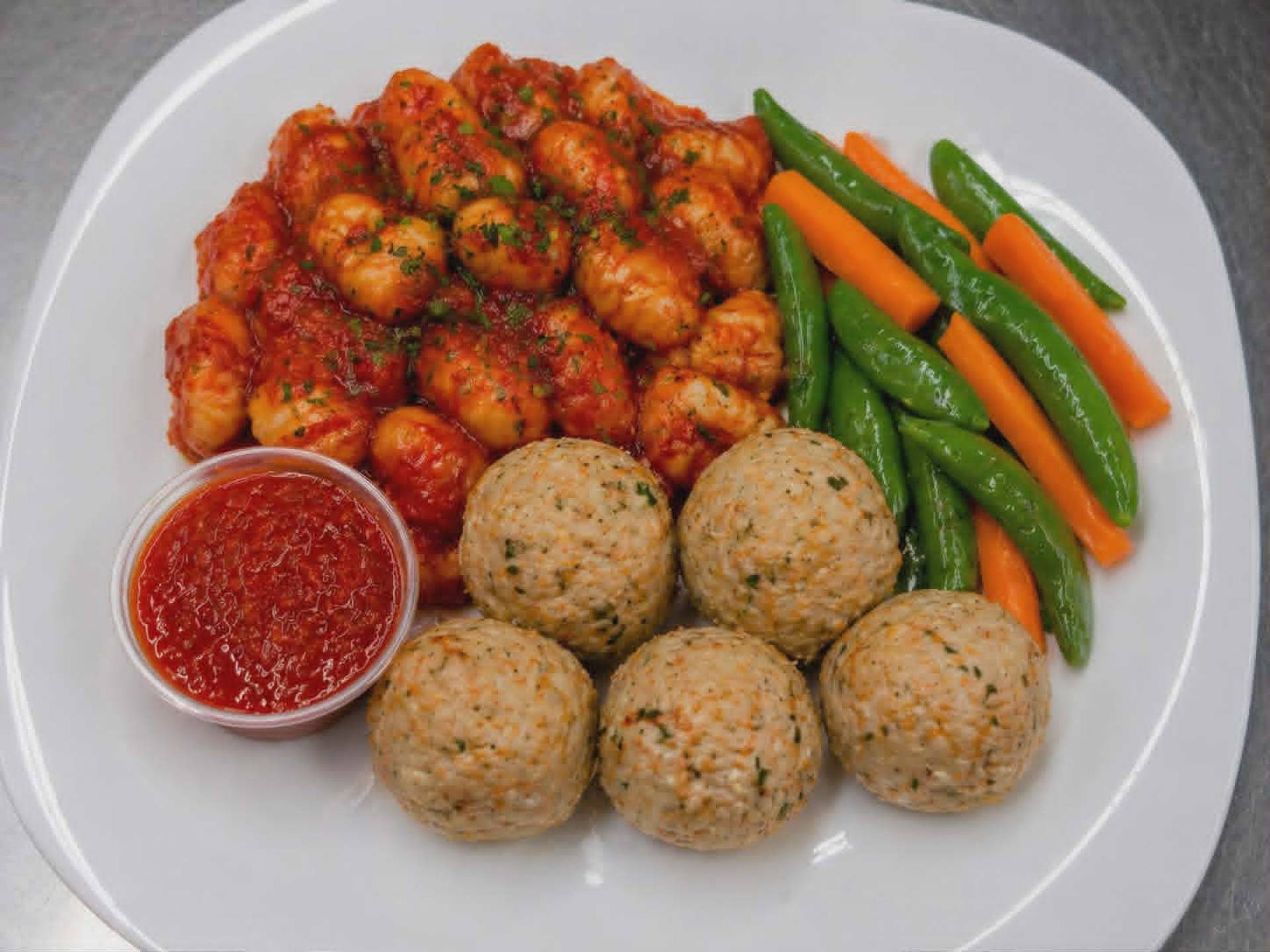 Boulettes de poulet façon pizza, gnocchis marinara, pois sucrés et carottes