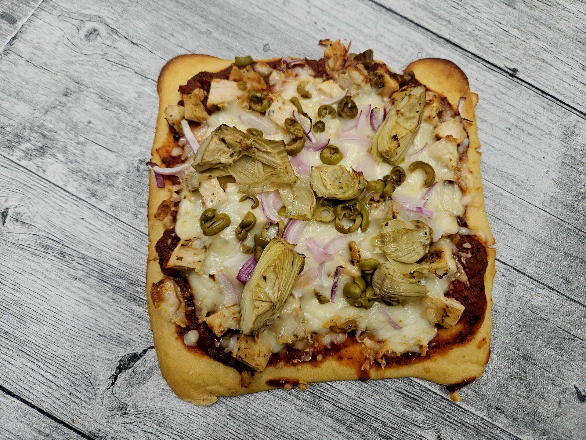 Pizza poulet, olives, artichauts, oignons rouges