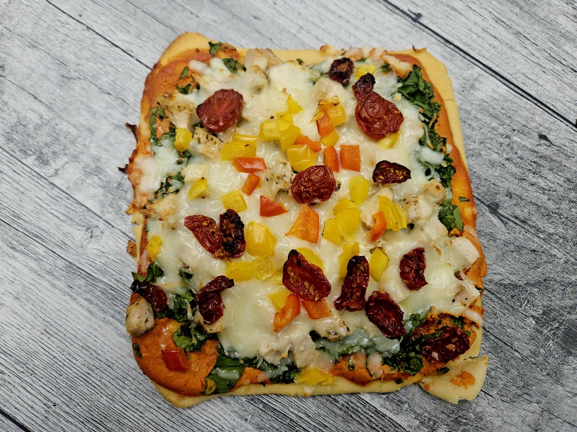 Pizza poulet, épinards, poivrons et tomates confites